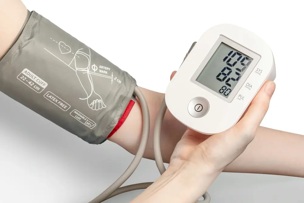 A digital blood pressure monitor on someone's arm